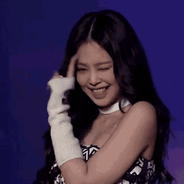 a woman wearing a choker and gloves is smiling and making a funny face .