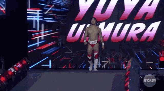 a wrestler named yuya umura is walking down a ramp