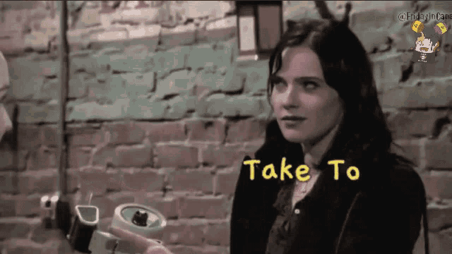 a woman is sitting in front of a brick wall and the words take to are visible