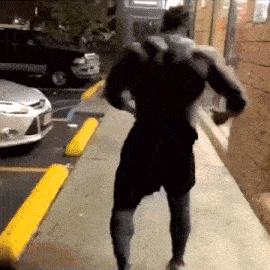 a man in black shorts is walking down a sidewalk with yellow curbs