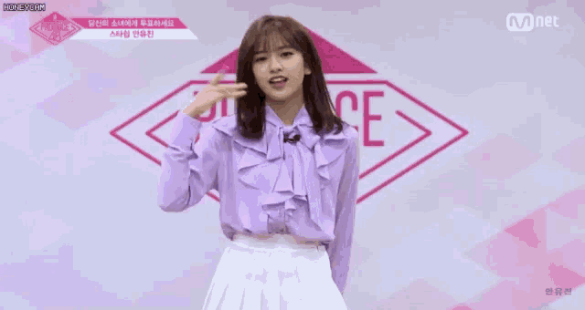 a girl in a purple top and white skirt is pointing at the camera