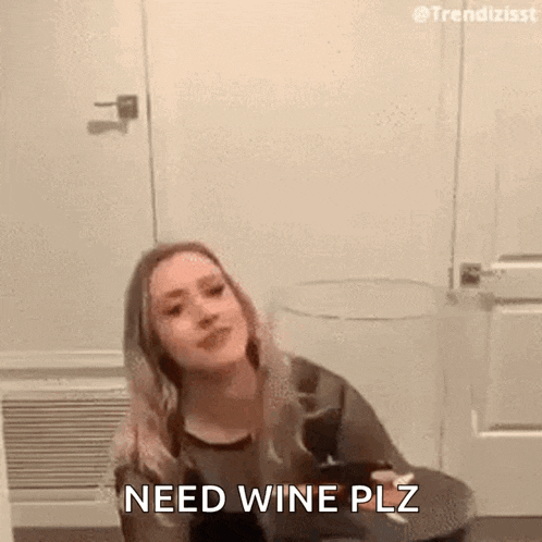 a woman is sitting in a room holding a glass of wine and saying `` need wine plz '' .