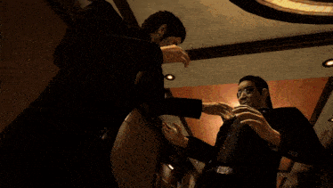 a man in a suit is standing next to another man in a room with a blue circle with the letter y on it