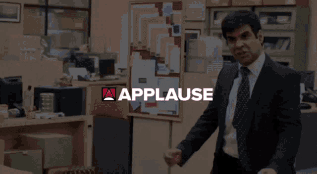 a man talking on a cell phone in front of applause