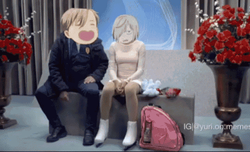 a man and a woman are sitting next to each other in front of a vase of flowers