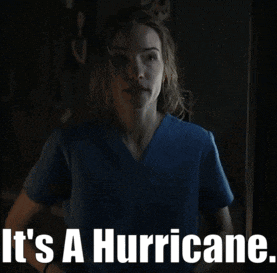 a woman in a blue scrub top with the words it 's a hurricane below her