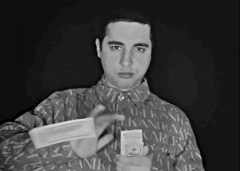 a man wearing a shirt that says karl bank is holding a stack of money