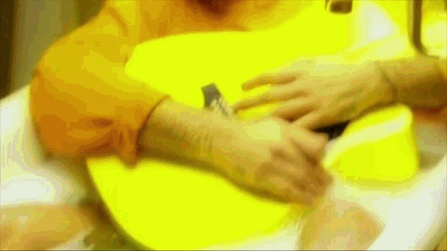 a blurry picture of a person holding a yellow guitar
