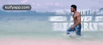 a shirtless man is kneeling in the ocean with the words `` happy birthday mega power star ram charan tej '' written above him .