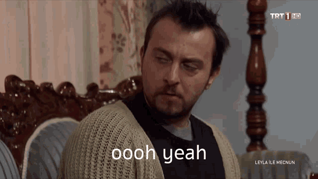 a man in a sweater says oooh yeah in front of a tv screen