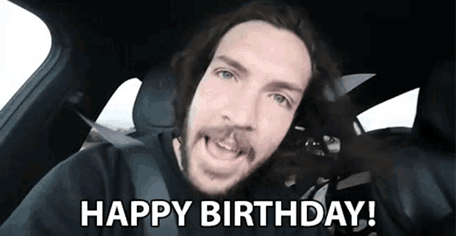a man in a car says happy birthday .