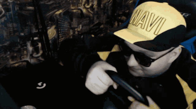 a man wearing sunglasses and a yellow hat with the word navo on it