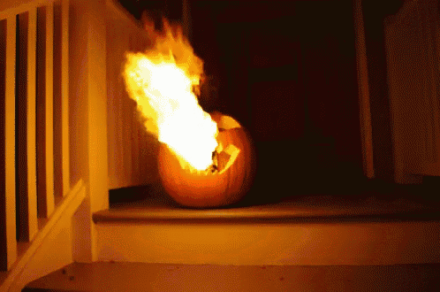 a burning pumpkin sits on the stairs of a house
