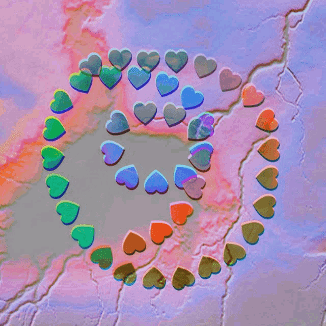 colorful hearts are arranged in a heart shape on a pink and purple background
