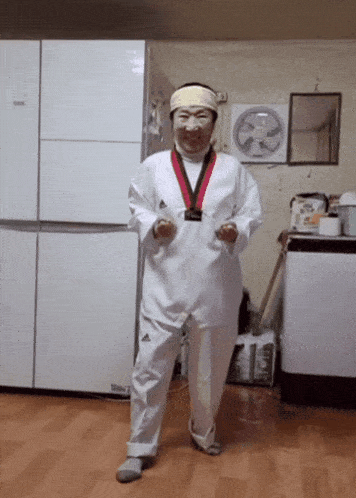 a woman in a taekwondo uniform is standing in front of a refrigerator