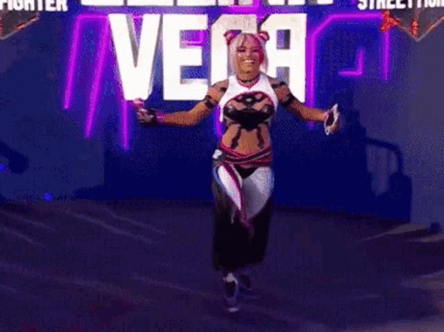a woman in a vega costume is standing in front of a sign that says street fighter