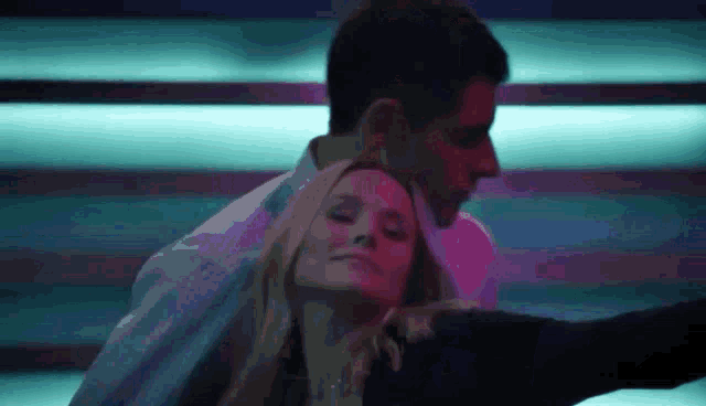 a man and a woman are hugging each other in a dark room