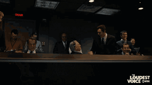 a group of people sitting in a dark room with a sign that says onair