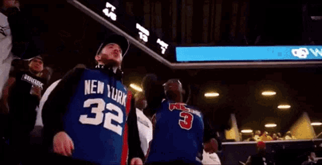 a man wearing a new york jersey stands in a crowd