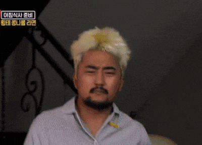 a man with blonde hair and a beard is wearing a striped shirt