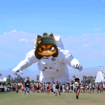 a group of people are gathered around a giant inflatable cat in an astronaut costume