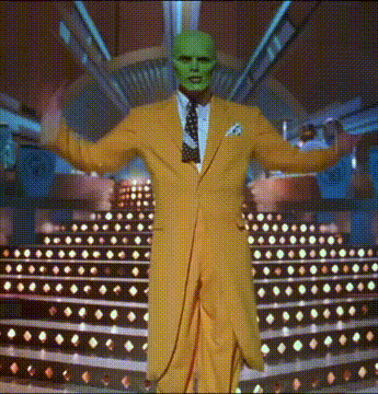 a man in a yellow suit and green mask is standing on a stage