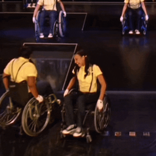 a group of people in wheelchairs are on a stage