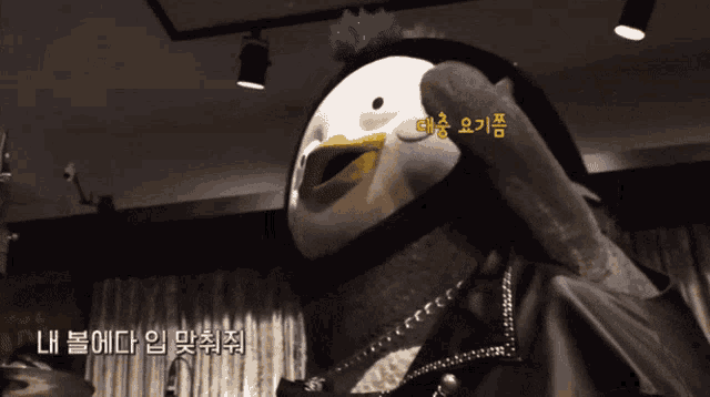 a stuffed animal with a yellow beak has a sticker on it that says ' lh '