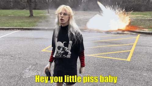 a person standing in a parking lot with the words hey you little piss baby