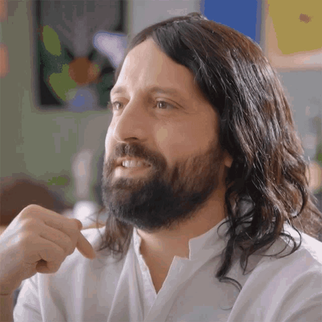 a man with long hair and a beard is smiling