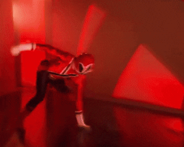 a red power ranger is kicking another power ranger in the face .