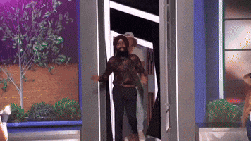 a man with a beard is walking through a door