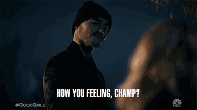 a man in a beanie is talking to a woman and says " how you feeling champ "