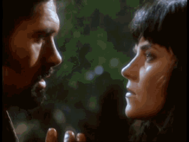 a man and a woman are looking at each other in a close up of their faces .