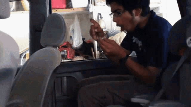 a man sitting in the back seat of a car wearing a t-shirt that says t-shirt