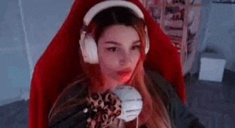 a woman wearing headphones and a mask is sitting in a red chair .