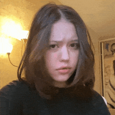 a woman with a piercing in her lip is making a face