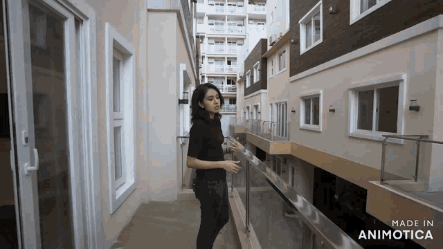 a woman is standing on a balcony with the words made in animotica behind her