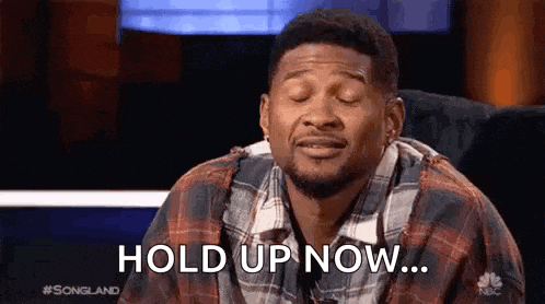 a man in a plaid shirt is sitting in front of a television with his eyes closed and says `` hold up now '' .