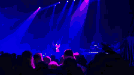a pixelated image of a crowd at a concert watching a band perform