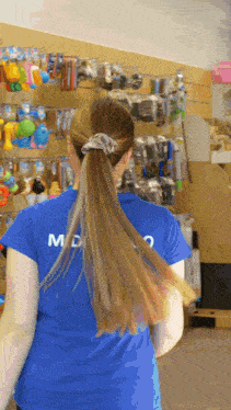 a woman with long hair wearing a blue shirt that says md on the back