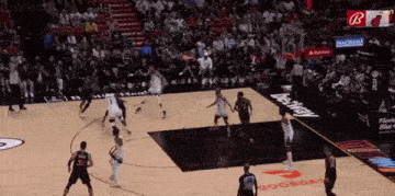 a basketball game is being played in front of a crowd with a banner that says ' bt ' on it