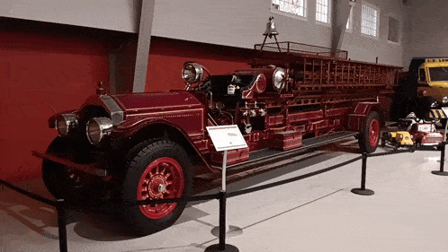 an old red fire truck is behind a fence with a sign that says " a.c. law " on it