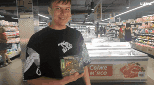 a man in a black shirt that says modern blood is holding a package
