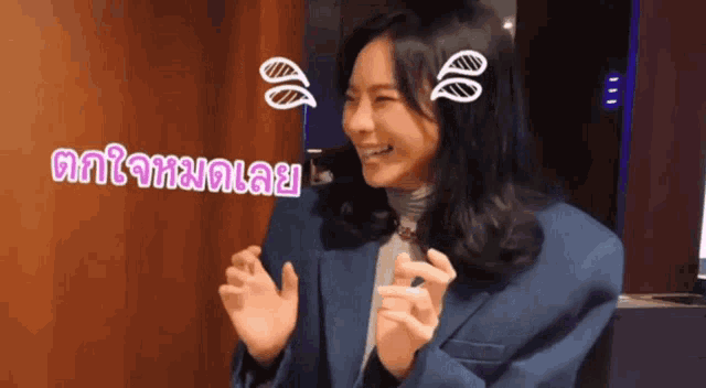 a woman in a blue jacket is making a funny face with a sticker on her forehead that says ' an '