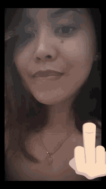 a woman with a necklace and a finger pointing at her face
