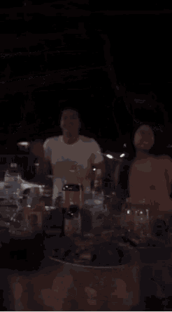 a group of people are sitting at a table with food and drinks