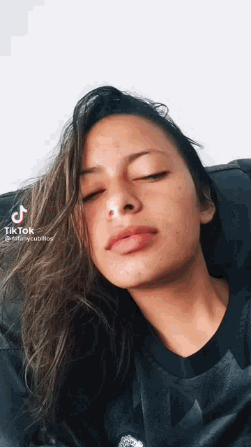 a woman with her eyes closed has a tiktok icon on her face