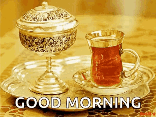 a cup of tea and a bowl of candy on a tray with the words good morning