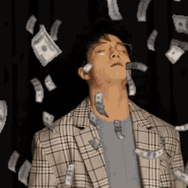 a man in a plaid jacket is surrounded by dollar bills
